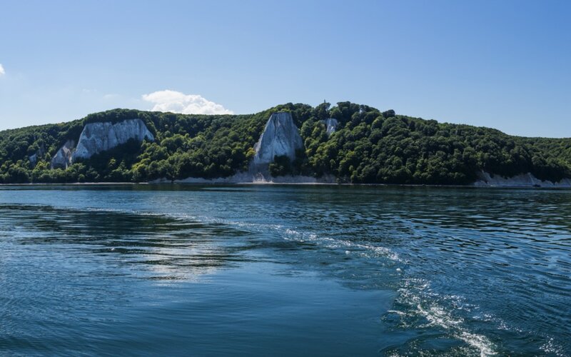Weiße Kreidefelsen an einer bewaldeten Küste der Ostsee